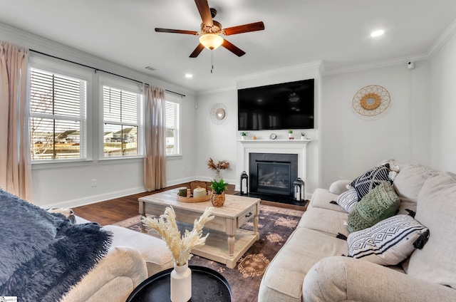 living area featuring dark wood finished floors, ceiling fan, baseboards, and ornamental molding