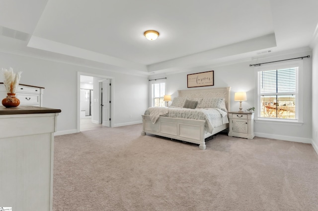 carpeted bedroom featuring baseboards, a raised ceiling, and visible vents