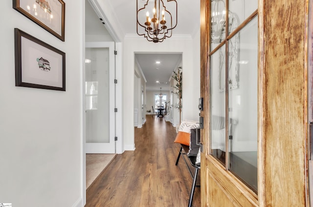 entryway featuring dark wood-style floors, baseboards, a chandelier, and crown molding