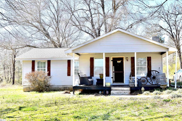 bungalow-style home featuring covered porch and a front yard