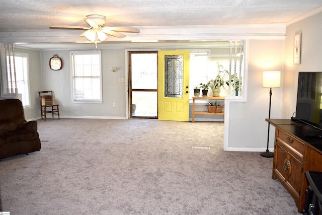 living area with crown molding, baseboards, carpet floors, a textured ceiling, and a ceiling fan