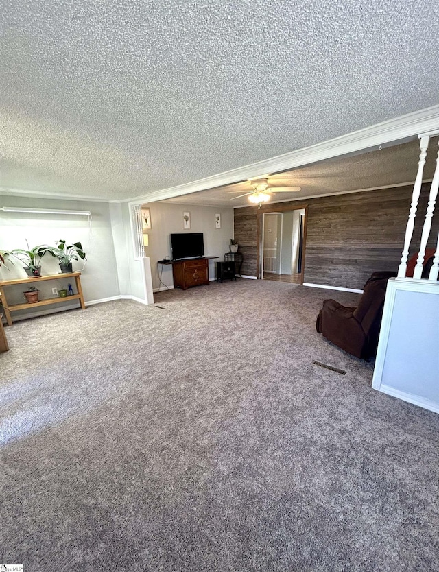 unfurnished living room featuring carpet flooring, a ceiling fan, and a textured ceiling