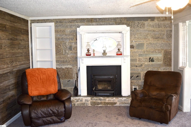 living area with a glass covered fireplace, crown molding, carpet flooring, and a textured ceiling