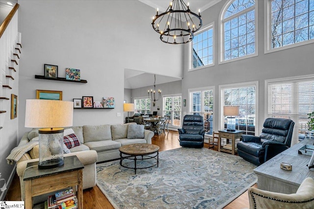 living room featuring a chandelier, ornamental molding, and wood finished floors