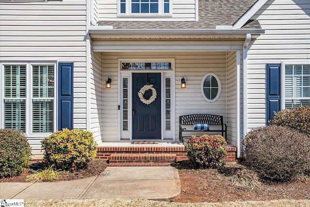 doorway to property with roof with shingles