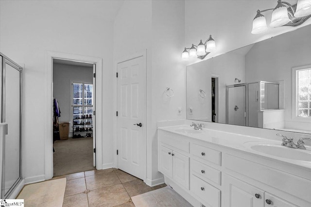 full bath with tile patterned flooring, a shower stall, double vanity, and a sink