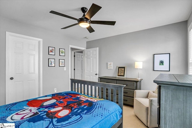 bedroom featuring light colored carpet and a ceiling fan