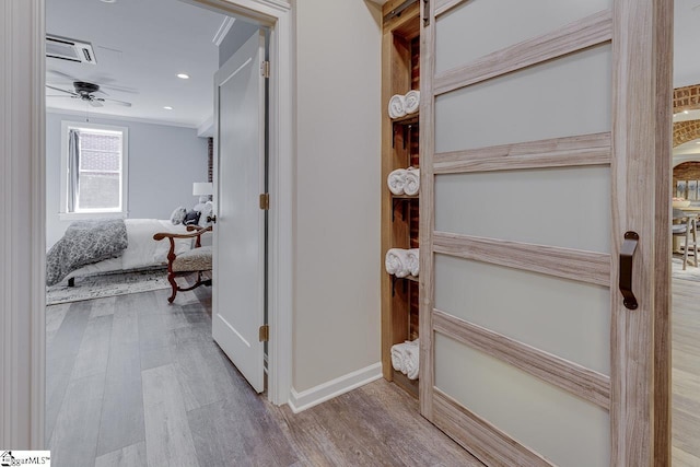 hall with crown molding, recessed lighting, wood finished floors, and baseboards