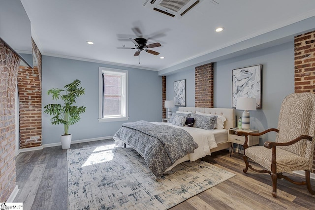 bedroom featuring wood finished floors, baseboards, brick wall, recessed lighting, and ornamental molding