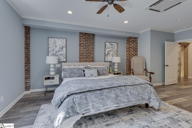 bedroom featuring visible vents, baseboards, wood finished floors, and crown molding