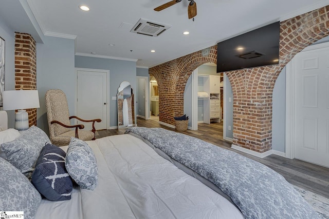 bedroom with brick wall, ornamental molding, recessed lighting, wood finished floors, and arched walkways