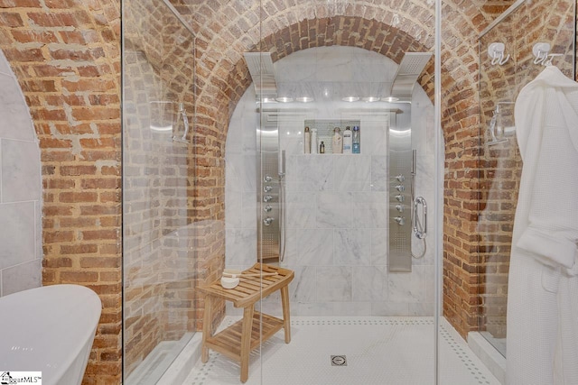 full bath with brick wall and tiled shower