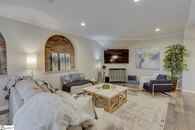 living room with recessed lighting, arched walkways, wood finished floors, and ornamental molding