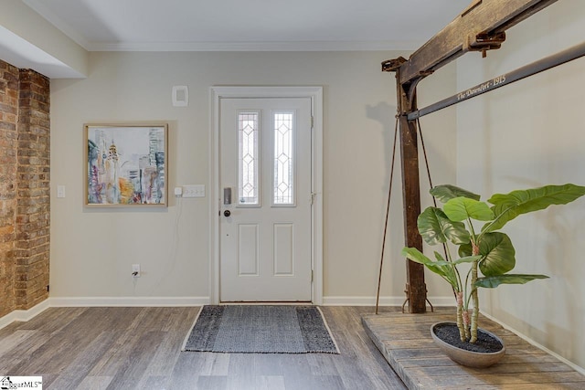 foyer entrance featuring baseboards, wood finished floors, and ornamental molding