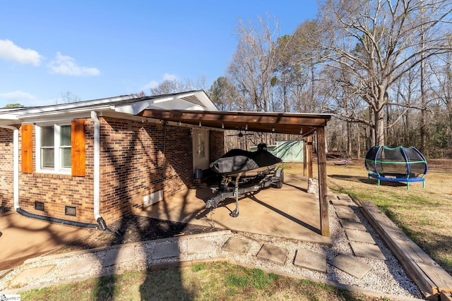 exterior space featuring an attached carport and a trampoline