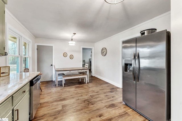 kitchen featuring crown molding, light wood finished floors, and appliances with stainless steel finishes