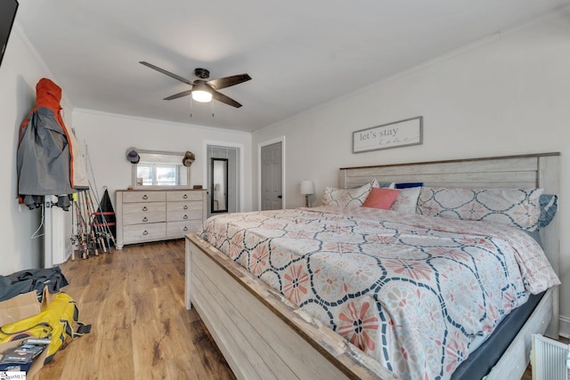 bedroom featuring wood finished floors, ceiling fan, and ornamental molding