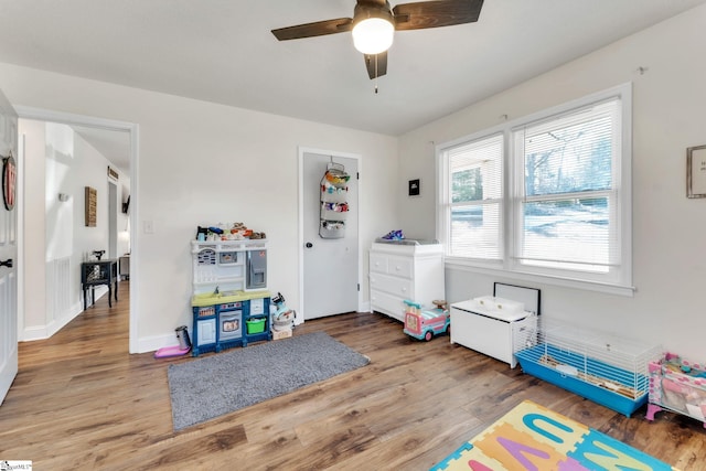 rec room with a ceiling fan, light wood-style floors, and baseboards