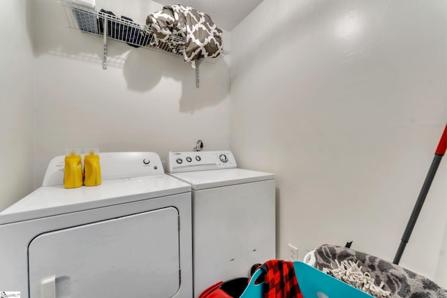 clothes washing area featuring laundry area and washer and clothes dryer