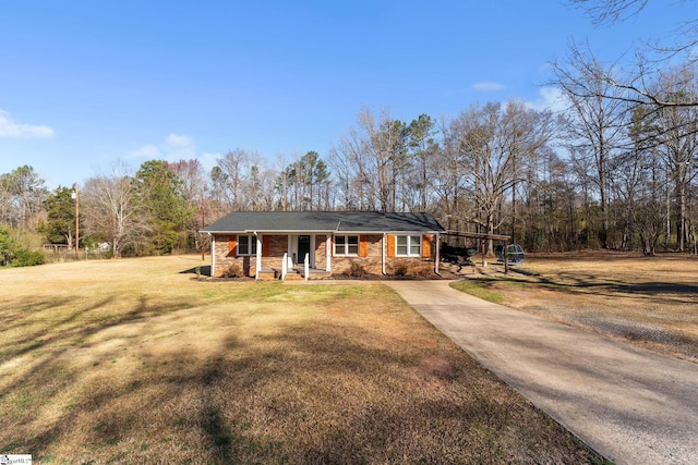 view of front of home featuring a porch, driveway, brick siding, and a front lawn