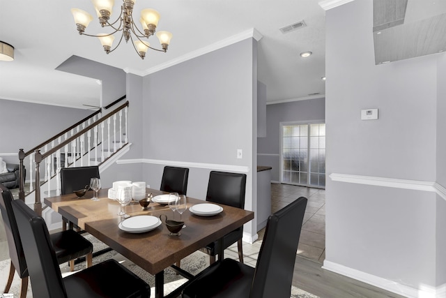 dining room featuring visible vents, baseboards, stairway, ornamental molding, and a notable chandelier