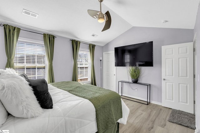 bedroom featuring visible vents, light wood-style flooring, lofted ceiling, and ceiling fan