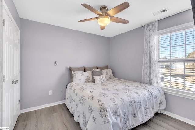 bedroom featuring visible vents, baseboards, and wood finished floors