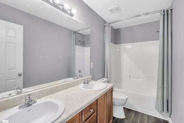 full bathroom featuring wood finished floors, toilet, visible vents, and a sink