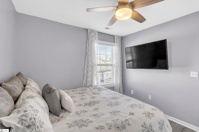 bedroom featuring a ceiling fan, visible vents, and baseboards