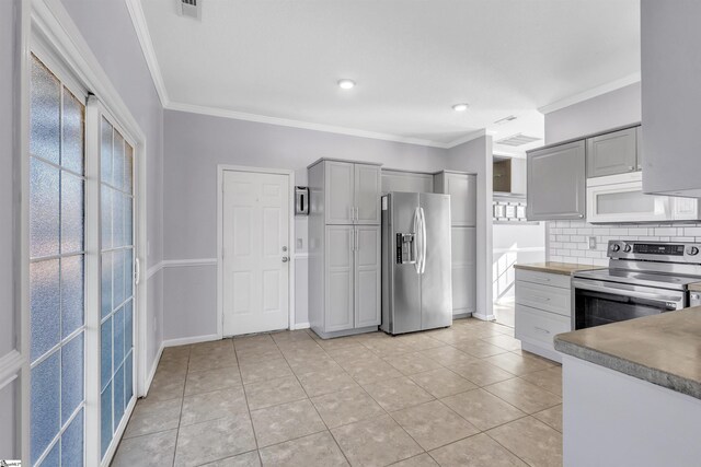 kitchen with tasteful backsplash, appliances with stainless steel finishes, gray cabinetry, and crown molding