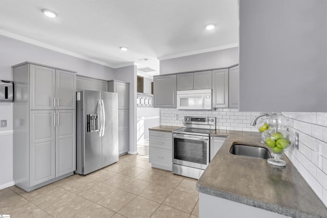 kitchen with backsplash, gray cabinets, stainless steel appliances, and crown molding