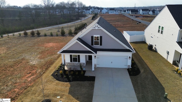 view of front facade with a front yard, fence, driveway, a porch, and central AC