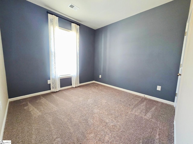 spare room with baseboards, visible vents, and carpet floors