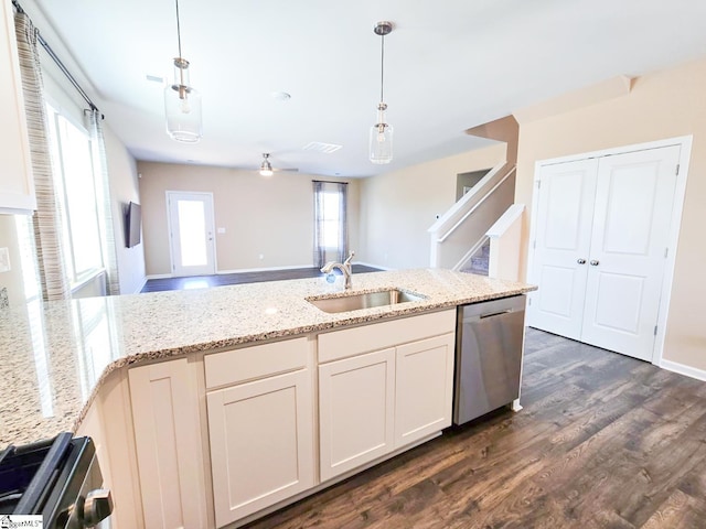 kitchen featuring dark wood finished floors, light stone counters, stainless steel dishwasher, stove, and a sink