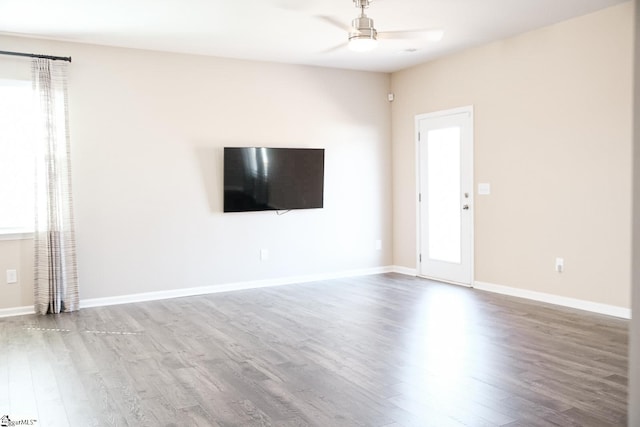 unfurnished living room featuring baseboards, ceiling fan, and wood finished floors