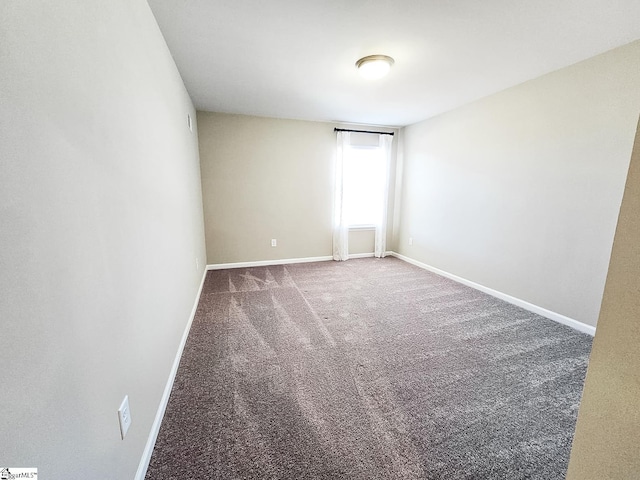 spare room with carpet and baseboards