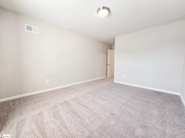 unfurnished room with light carpet, visible vents, and baseboards