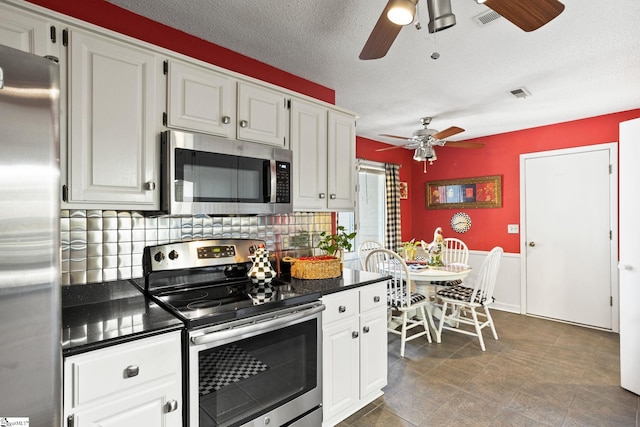 kitchen featuring dark countertops, a ceiling fan, visible vents, and stainless steel appliances