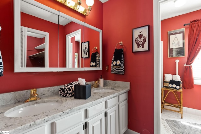 bathroom with double vanity, baseboards, and a sink