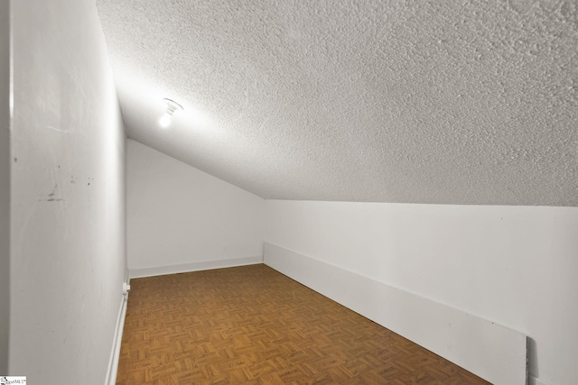 bonus room featuring lofted ceiling and a textured ceiling