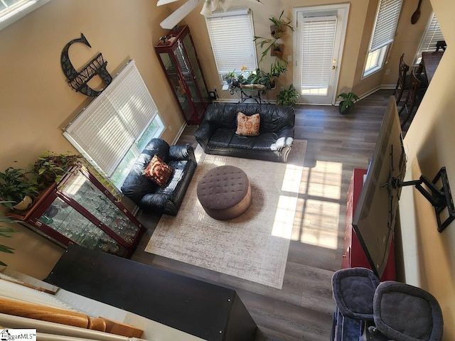 living room with a healthy amount of sunlight, wood finished floors, baseboards, and ceiling fan