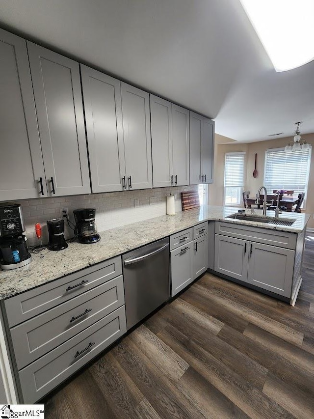 kitchen with dark wood finished floors, a peninsula, a sink, gray cabinetry, and dishwasher