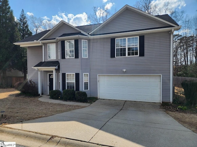 traditional-style home with an attached garage, concrete driveway, and fence