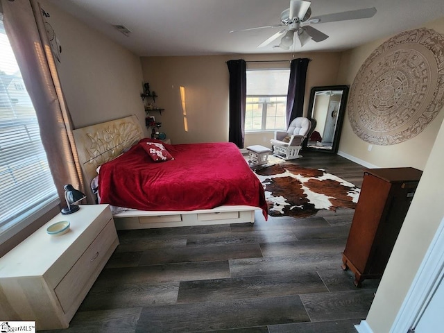 bedroom featuring visible vents, a ceiling fan, baseboards, and wood finished floors