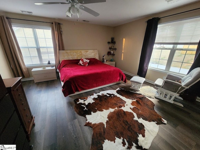 bedroom with visible vents, baseboards, wood finished floors, and a ceiling fan