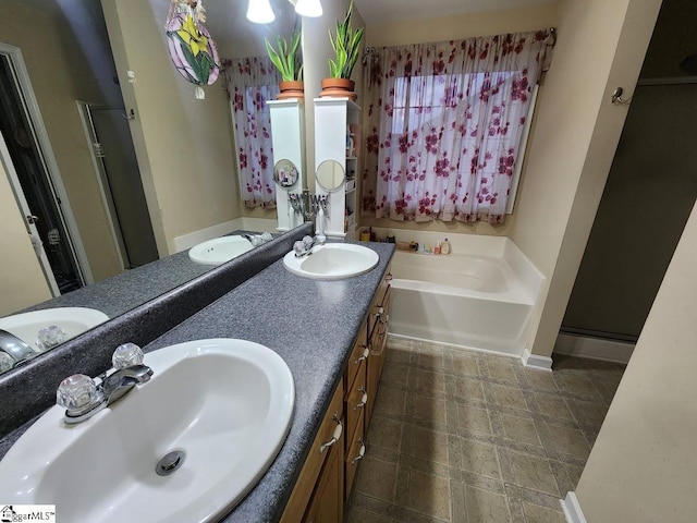 bathroom with a garden tub, a stall shower, and a sink