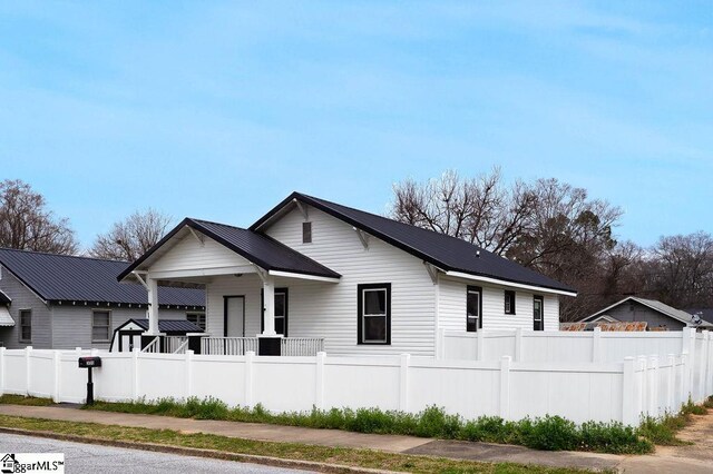 view of front of property with a fenced front yard and metal roof