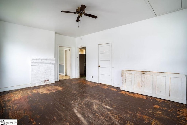 unfurnished bedroom with attic access, a ceiling fan, and hardwood / wood-style floors