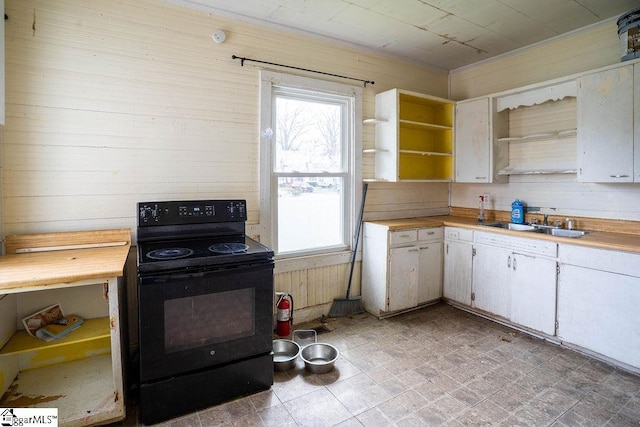 kitchen with open shelves, black electric range, a healthy amount of sunlight, and a sink