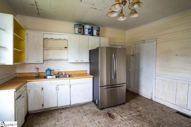 kitchen featuring visible vents, an inviting chandelier, open shelves, freestanding refrigerator, and a sink